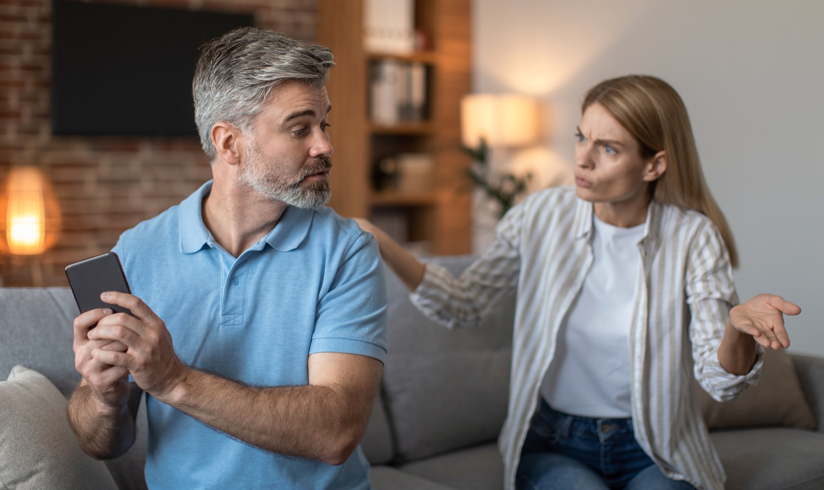 Hombre y mujer discutiendo, el hombre tomando el teléfono